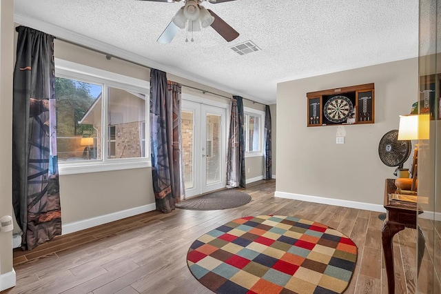 entryway with visible vents, wood finished floors, a textured ceiling, french doors, and a ceiling fan