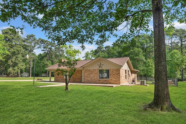 ranch-style house with brick siding, fence, central AC unit, and a front lawn