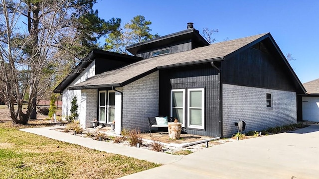 view of side of property with a garage and brick siding