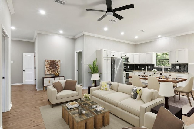 131 Oak Ln, Hemphill, TX 75948 - living room with visible vents, light wood-style flooring, crown molding, and a ceiling fan