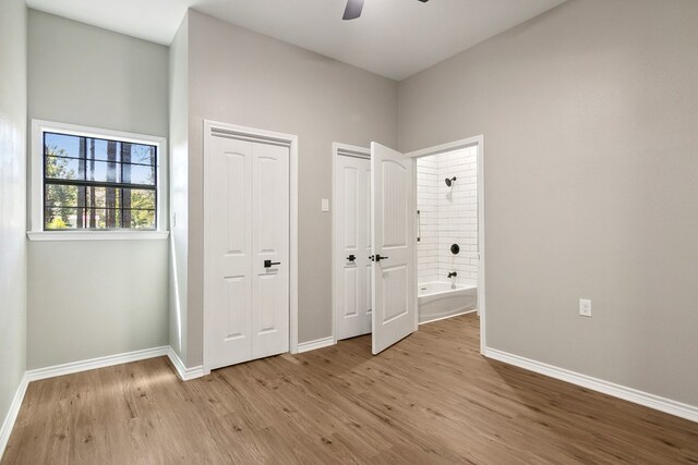 131 Oak Ln, Hemphill, TX 75948 - unfurnished bedroom featuring connected bathroom, baseboards, multiple closets, light wood-style flooring, and a ceiling fan