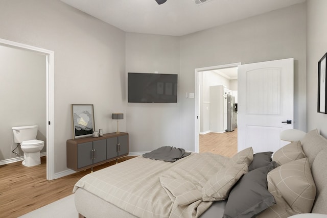 131 Oak Ln, Hemphill, TX 75948 - bedroom with visible vents, ensuite bath, freestanding refrigerator, light wood-style floors, and baseboards