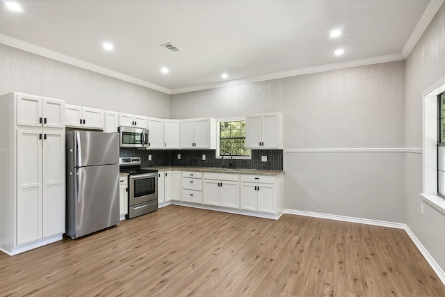 131 Oak Ln, Hemphill, TX 75948 - kitchen featuring light wood-type flooring, decorative backsplash, white cabinets, stainless steel appliances, and a sink