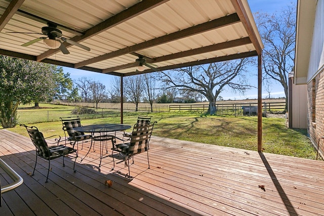 deck featuring ceiling fan, a yard, and a rural view