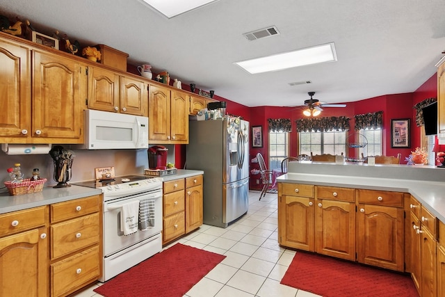 kitchen with ceiling fan, light tile patterned floors, kitchen peninsula, and white appliances