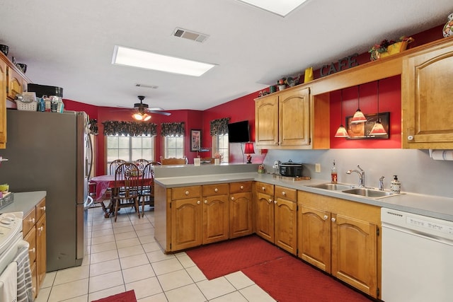 kitchen with decorative light fixtures, ceiling fan, kitchen peninsula, sink, and white appliances