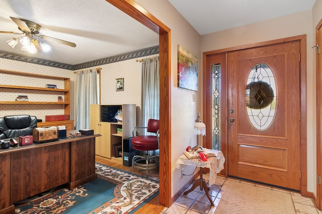 tiled foyer featuring ceiling fan