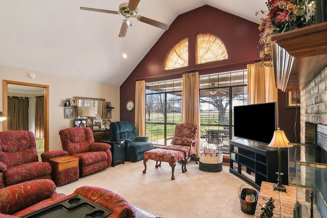 carpeted living room featuring ceiling fan, a fireplace, and high vaulted ceiling