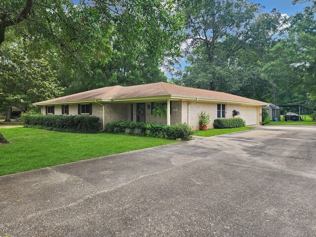 2104 Pinecrest Dr, Jasper, TX 75951 - ranch-style house featuring asphalt driveway, a front yard, a garage, and brick siding