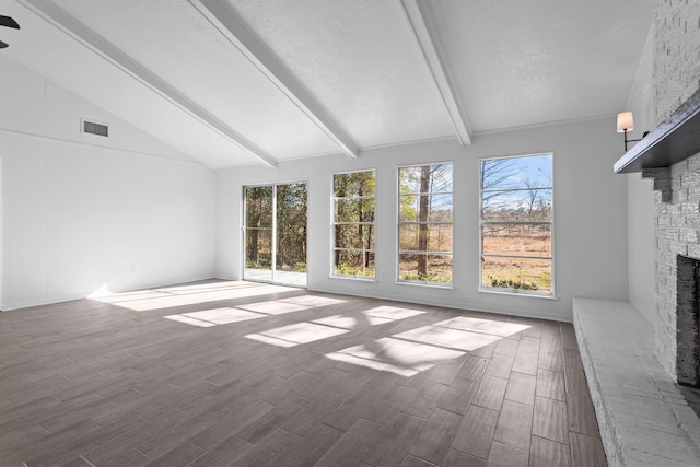 unfurnished sunroom with vaulted ceiling with beams and a brick fireplace