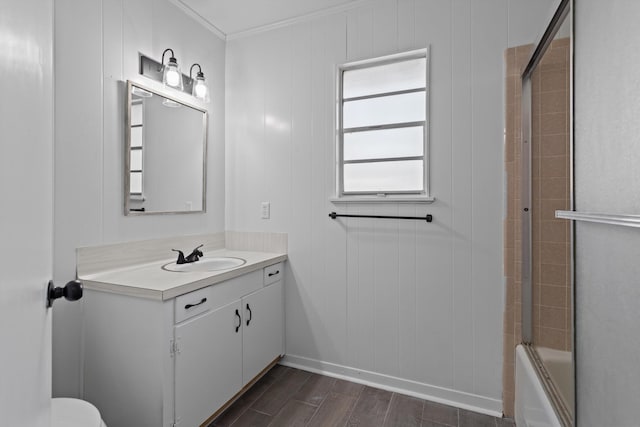 full bathroom with hardwood / wood-style floors, combined bath / shower with glass door, wooden walls, vanity, and ornamental molding