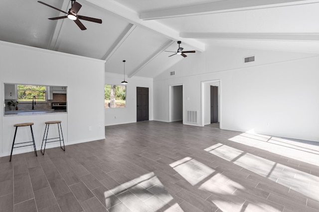 unfurnished living room with beam ceiling, dark hardwood / wood-style flooring, high vaulted ceiling, and ceiling fan