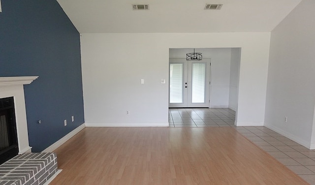 157 Sandalwood, Lufkin, TX 75904 - unfurnished living room with a fireplace, baseboards, wood finished floors, and french doors