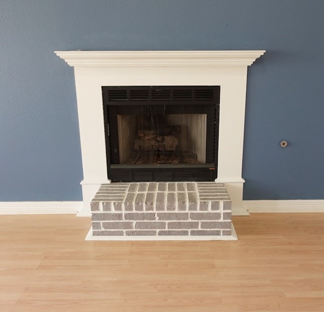 157 Sandalwood, Lufkin, TX 75904 - detailed view of baseboards, wood finished floors, and a fireplace with raised hearth