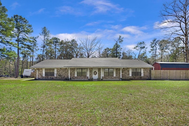 view of front of home with fence, a front lawn, and brick siding