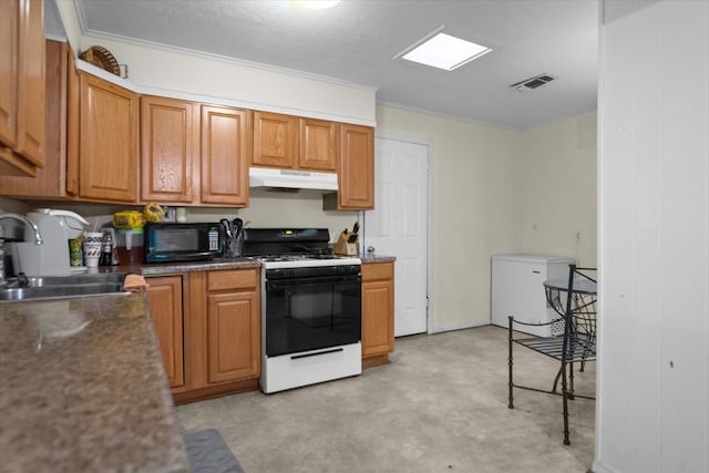 408 Bob St, Lufkin, TX 75904 - kitchen with under cabinet range hood, range with gas cooktop, visible vents, a sink, and black microwave