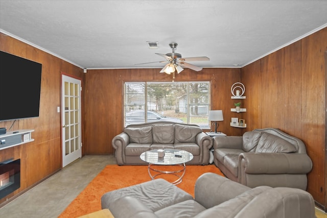 408 Bob St, Lufkin, TX 75904 - living area with visible vents, a ceiling fan, wood walls, and crown molding
