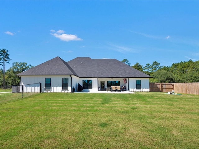 rear view of house with a patio and a lawn