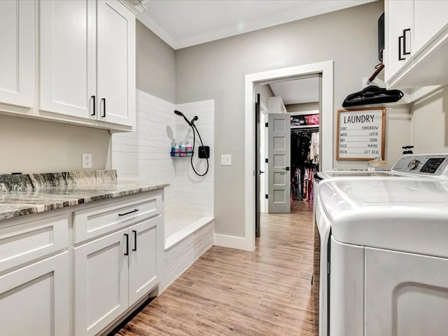 clothes washing area with cabinets, ornamental molding, separate washer and dryer, and light wood-type flooring