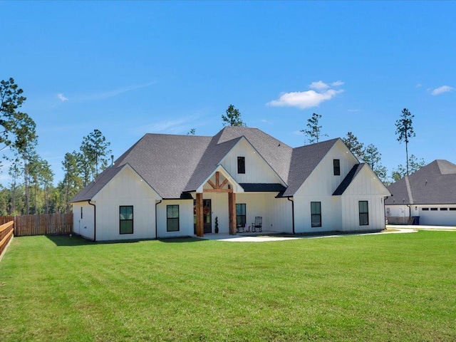 back of house with a patio and a lawn