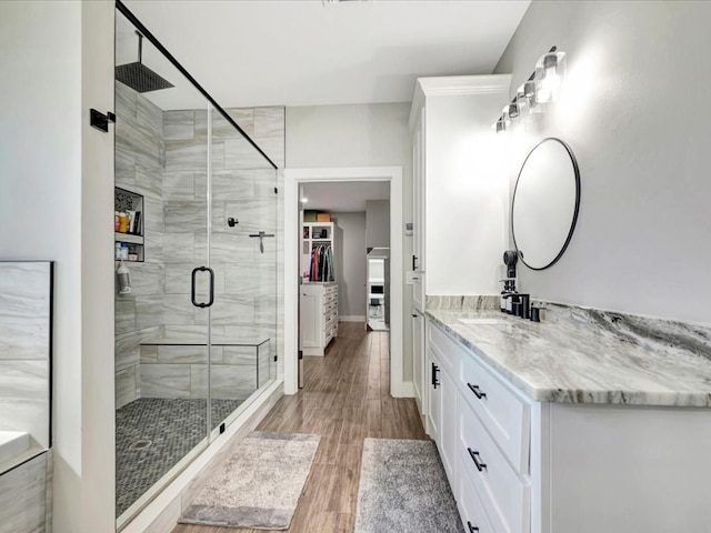 bathroom featuring vanity, an enclosed shower, and wood-type flooring