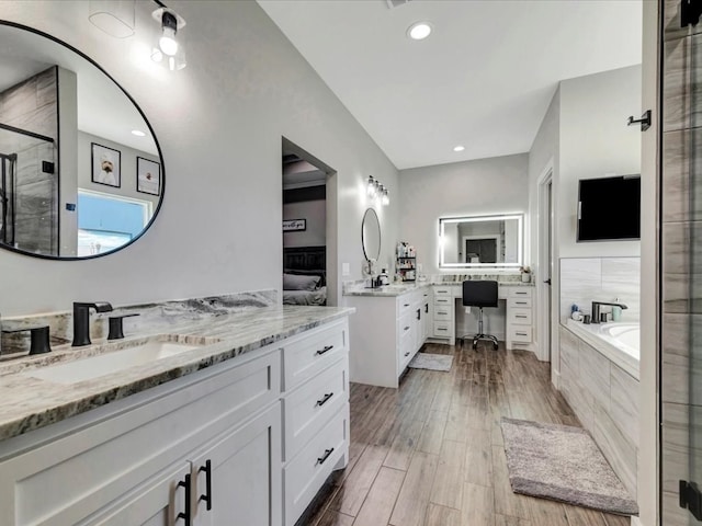 bathroom featuring hardwood / wood-style flooring, vanity, and independent shower and bath