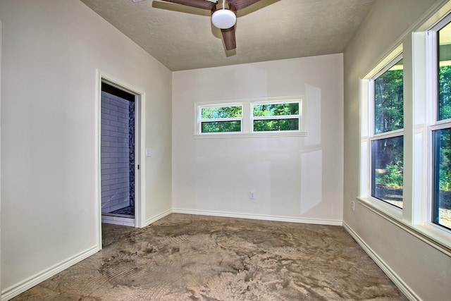 carpeted spare room with a textured ceiling, ceiling fan, and a healthy amount of sunlight