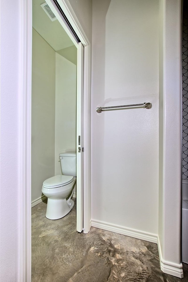 bathroom featuring toilet and concrete flooring