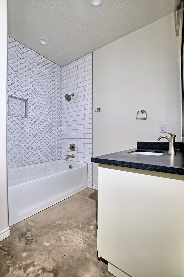 bathroom with vanity, a textured ceiling, and tiled shower / bath