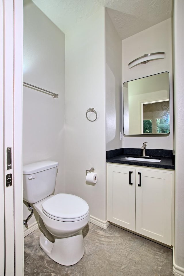 bathroom with vanity, a textured ceiling, and toilet