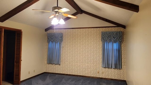 carpeted empty room with a textured ceiling, vaulted ceiling with beams, and ceiling fan