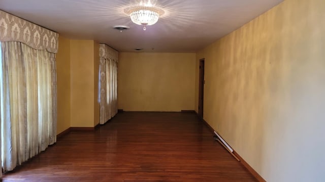 hall featuring an inviting chandelier and dark wood-type flooring