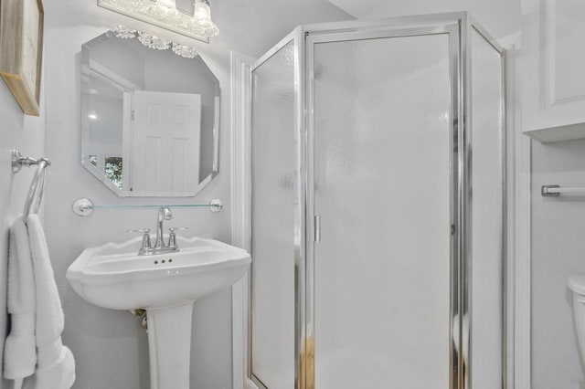 bathroom featuring a chandelier, toilet, and a shower with shower door