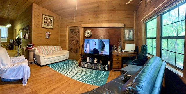 living room with light hardwood / wood-style flooring, vaulted ceiling, wooden walls, and wood ceiling