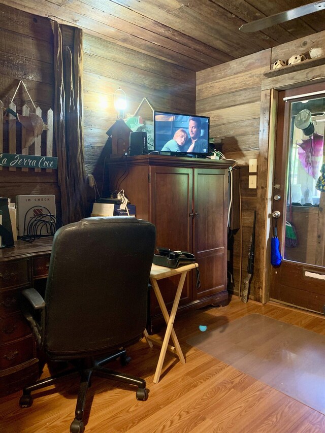 home office with light hardwood / wood-style flooring, wooden walls, and wood ceiling