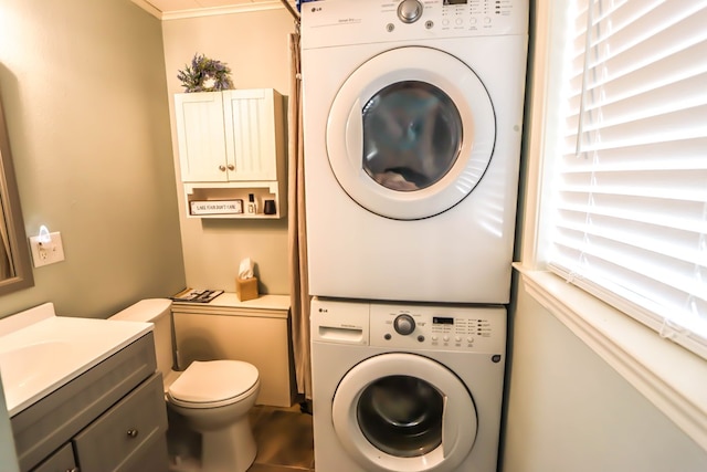 laundry room featuring stacked washer / drying machine and laundry area