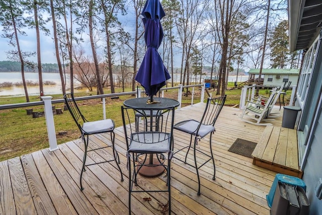 wooden terrace with a yard and a water view