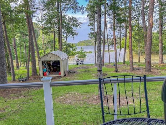 view of yard with an outbuilding, a water view, and a shed