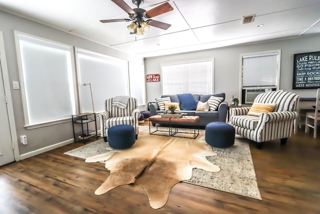 living room with visible vents, wood finished floors, cooling unit, baseboards, and ceiling fan