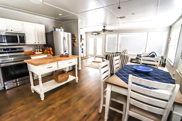 kitchen with a ceiling fan, visible vents, dark wood finished floors, appliances with stainless steel finishes, and wood counters