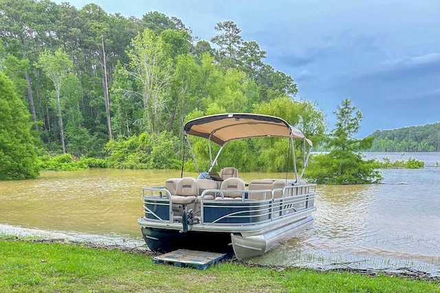 dock area featuring a wooded view and a water view