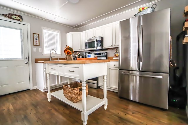 kitchen featuring dark wood finished floors, white cabinets, appliances with stainless steel finishes, and wood counters