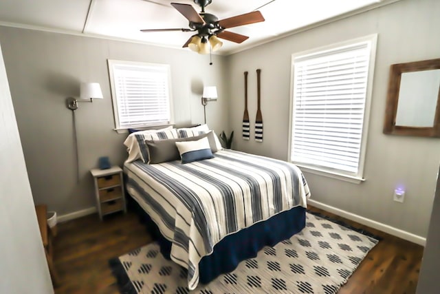 bedroom featuring multiple windows, baseboards, dark wood-type flooring, and ceiling fan