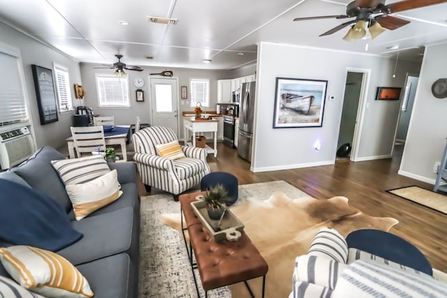 living area with visible vents, baseboards, ornamental molding, a ceiling fan, and dark wood-style flooring