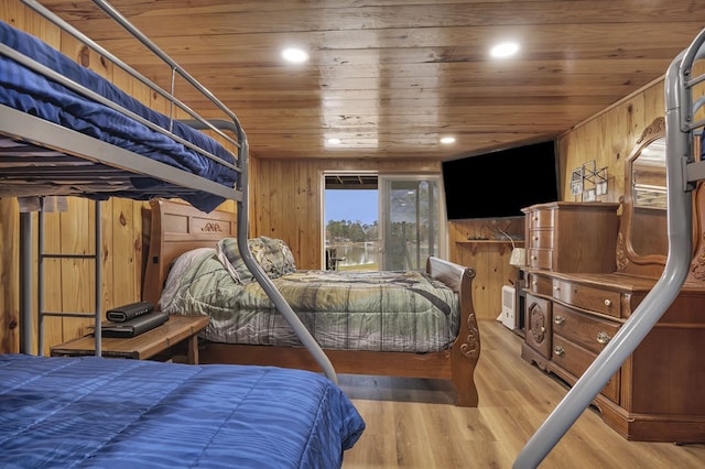 bedroom with wooden walls, wood ceiling, and light hardwood / wood-style flooring