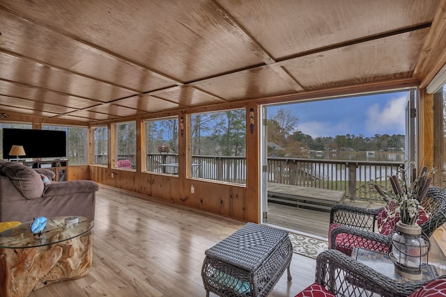 sunroom featuring wood ceiling and a water view