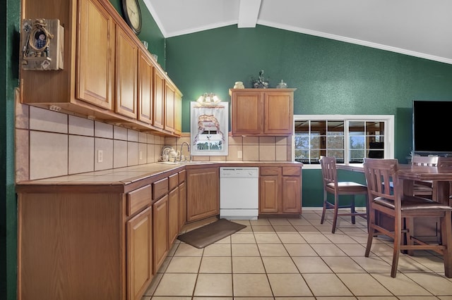 kitchen featuring sink, vaulted ceiling with beams, tile counters, white dishwasher, and backsplash