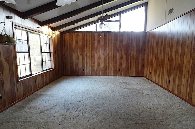 empty room with vaulted ceiling with beams, ceiling fan, wooden walls, and carpet