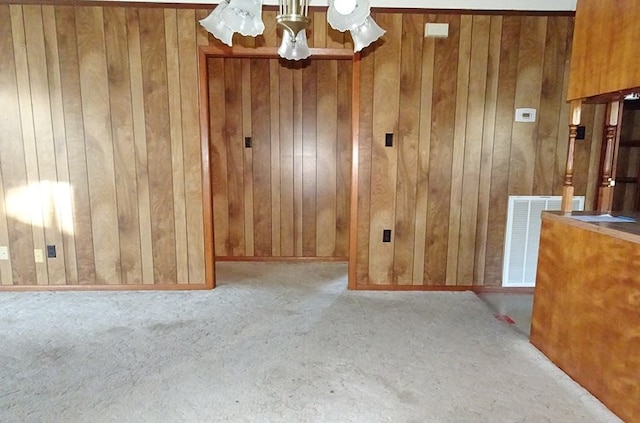 unfurnished dining area with light carpet and wood walls