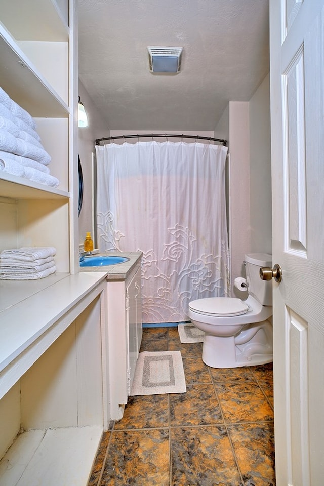 full bath with vanity, toilet, and visible vents
